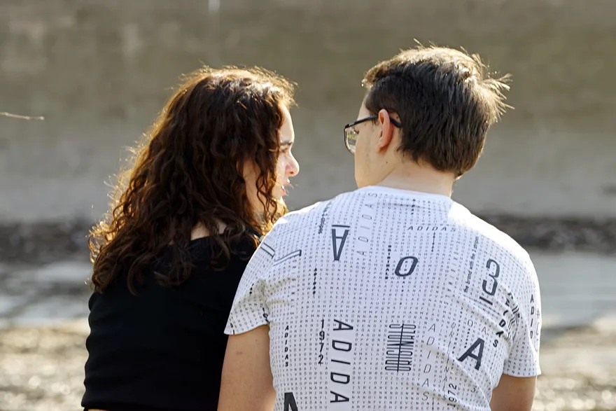 Couple talking face to face by the sea
